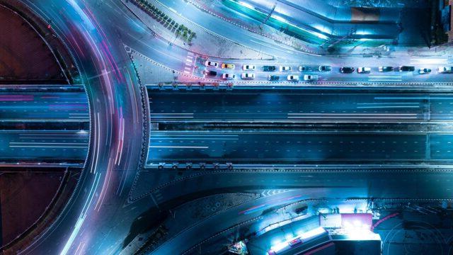 Aerial view of an expressway at night with car traffic above intersection